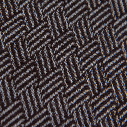 Dettaglio e texture tessuto della Sciarpa in 100% cashmere marrone, Made in Italy, con intramontabile pattern ad intreccio e lavorazione leggera in 3D che accentua la percezione al tatto. Il cashmere di alta qualità offre straordinaria finezza, proprietà termoisolanti e garantisce calore, protezione e leggerezza.