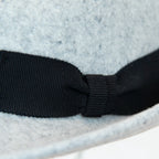 Dettaglio nastro e tessuto del cappello in feltro di lana grigio chiaro, Made in Italy, con tesa corta rialzata sul retro e nastro in gros-grain 3 cm nero. Realizzato da un antico cappellificio italiano, unisce tradizione e stile.