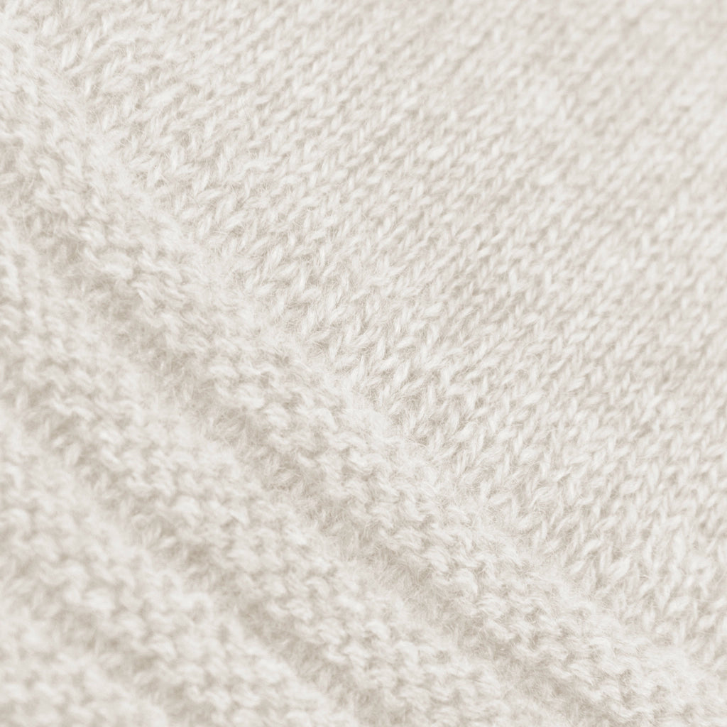 Dettagli e texture del guanto panna in 100% cashmere a coste inglesi, indossabile lungo o corto, pregiata manifattura Made in Italy.