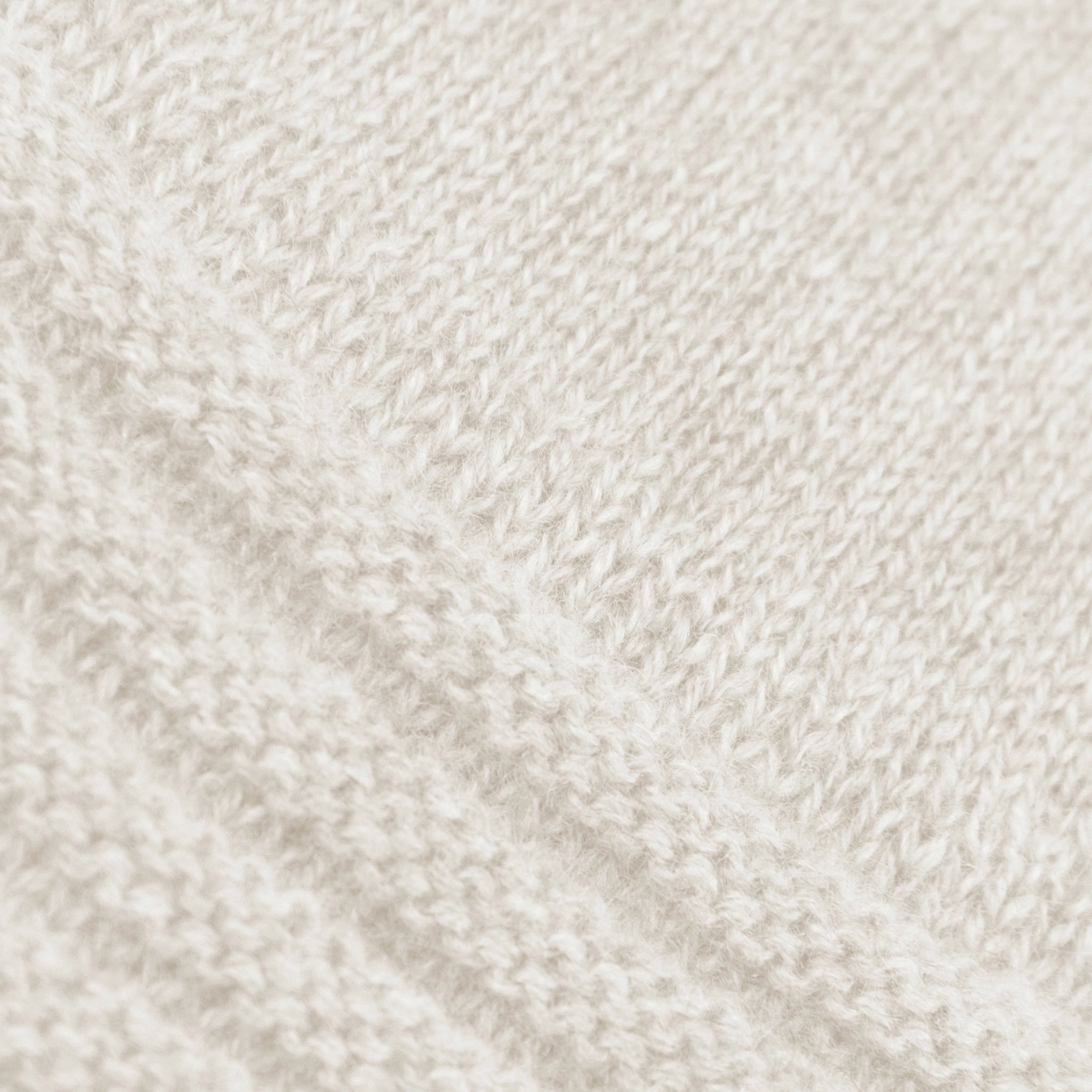 Dettagli e texture del guanto panna in 100% cashmere a coste inglesi, indossabile lungo o corto, pregiata manifattura Made in Italy.