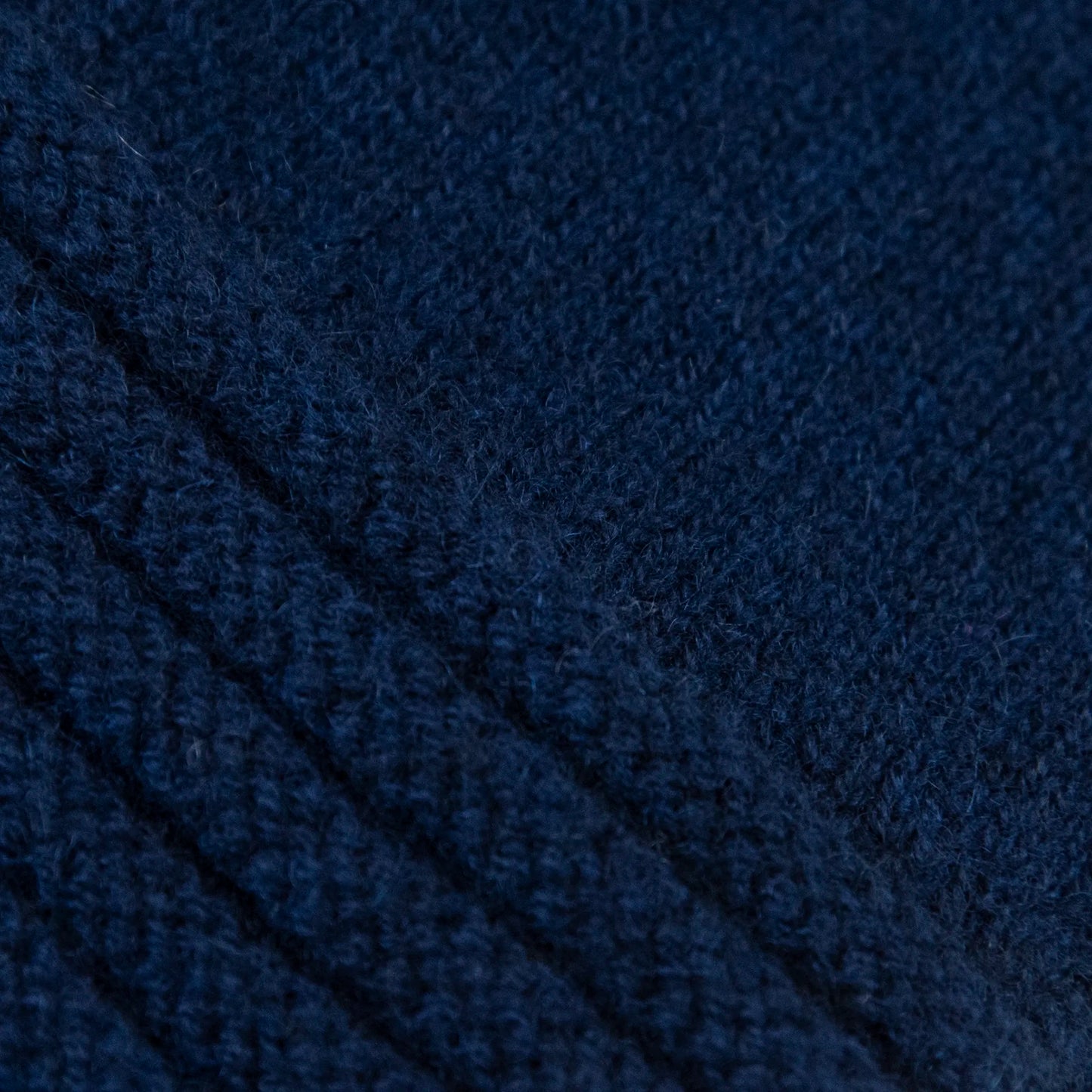 Dettagli e texture tessuto del guanto blu in 100% cashmere a coste inglesi, indossabile lungo o corto, pregiata manifattura Made in Italy.