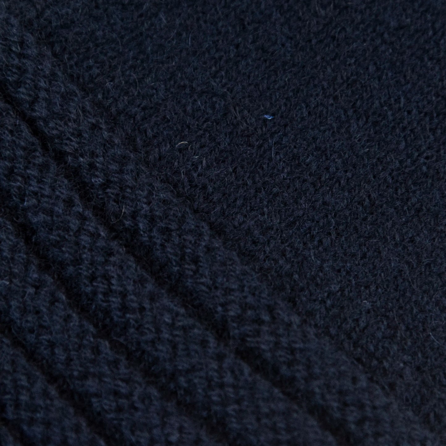 Dettagli e texture tessuto del guanto blu in 100% cashmere a coste inglesi, indossabile lungo o corto, pregiata manifattura Made in Italy.