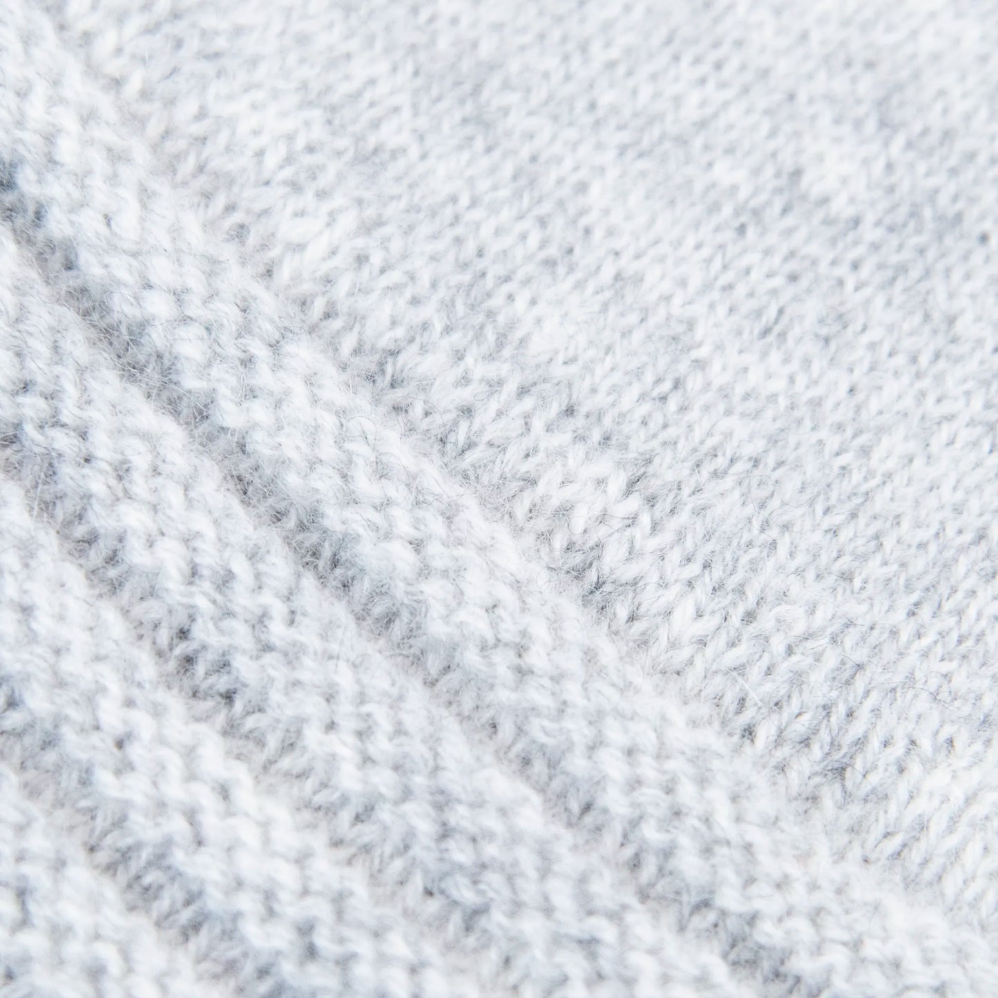 Dettagli e texture tessuto del guanto grigio in 100% cashmere a coste inglesi, indossabile lungo o corto, pregiata manifattura Made in Italy.