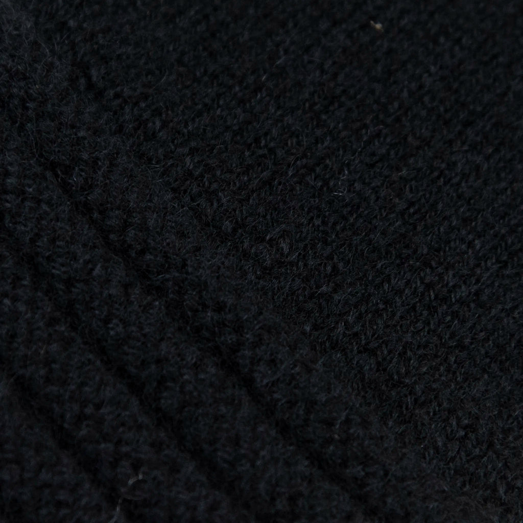 Dettagli e texture tessuto del guanto nero in 100% cashmere a coste inglesi, indossabile lungo o corto, pregiata manifattura Made in Italy.
