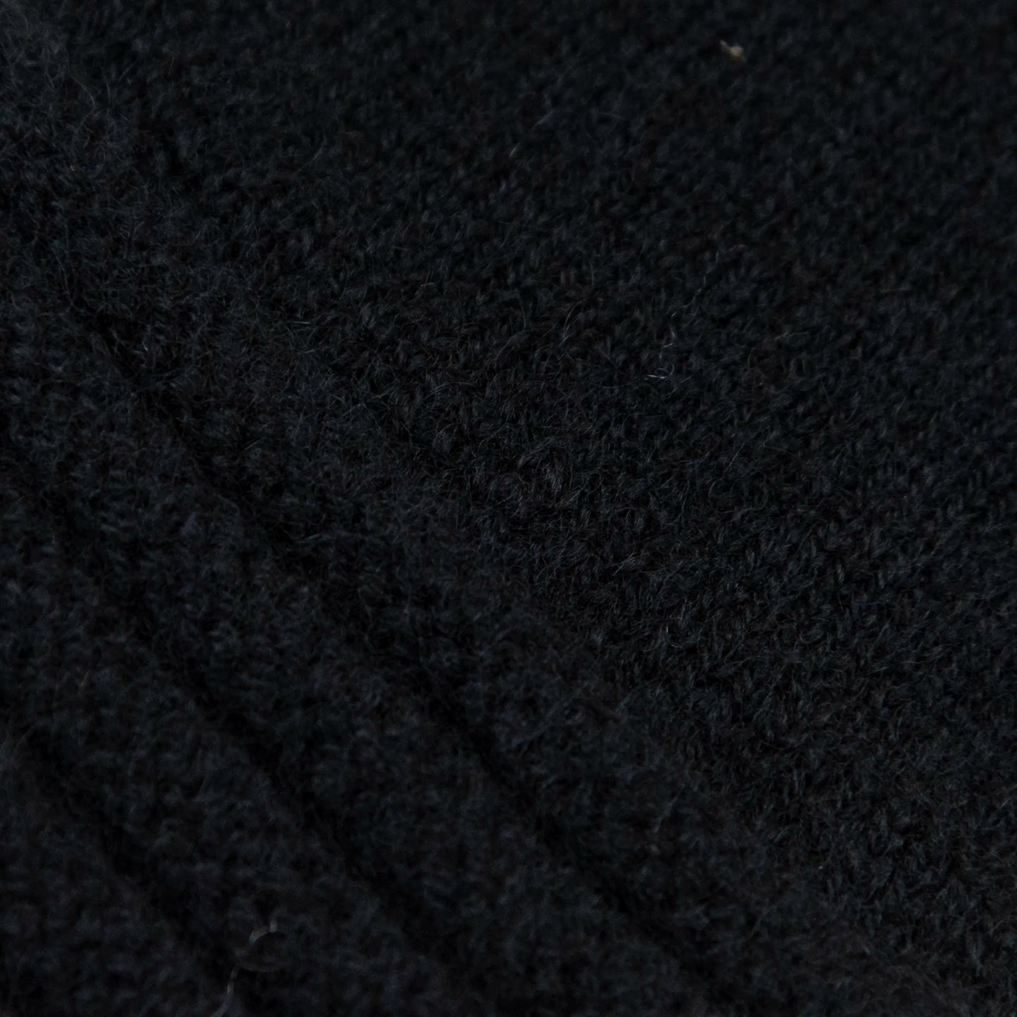 Dettagli e texture tessuto del guanto nero in 100% cashmere a coste inglesi, indossabile lungo o corto, pregiata manifattura Made in Italy.