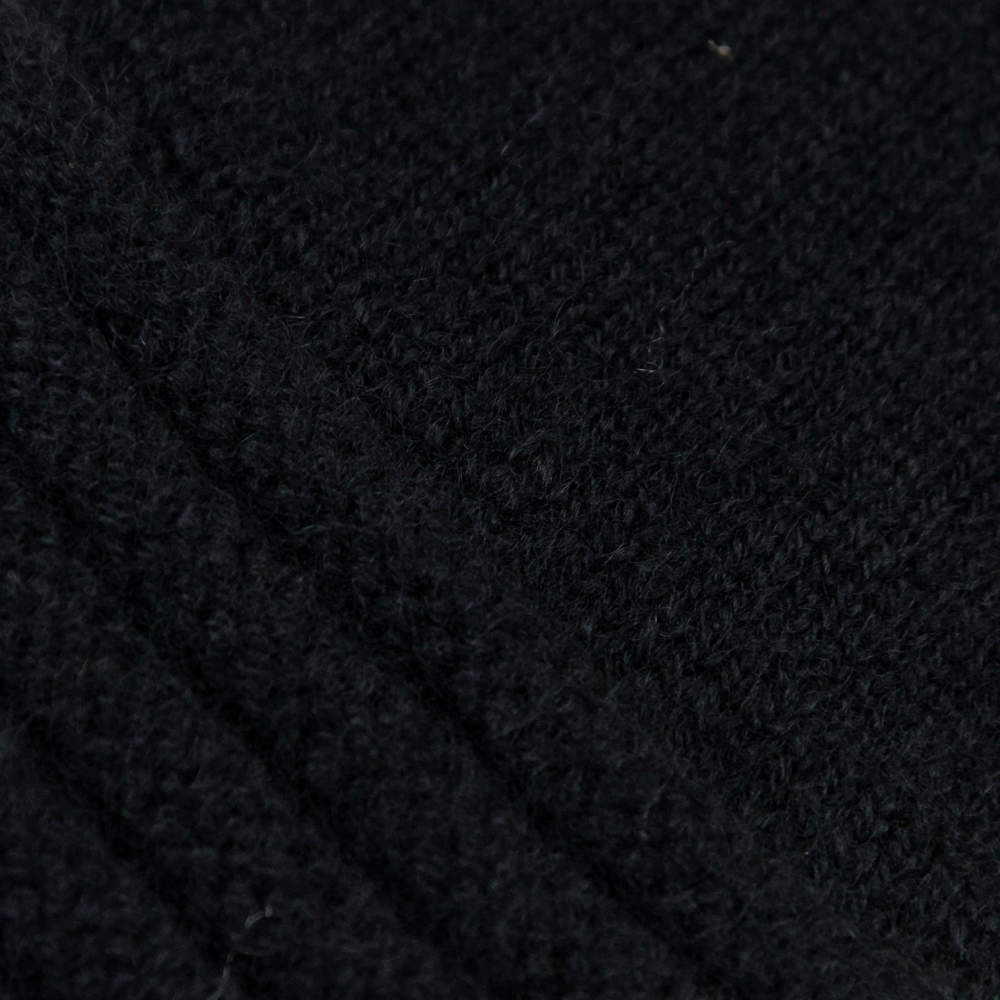 Dettagli e texture tessuto del guanto nero in 100% cashmere a coste inglesi, indossabile lungo o corto, pregiata manifattura Made in Italy.