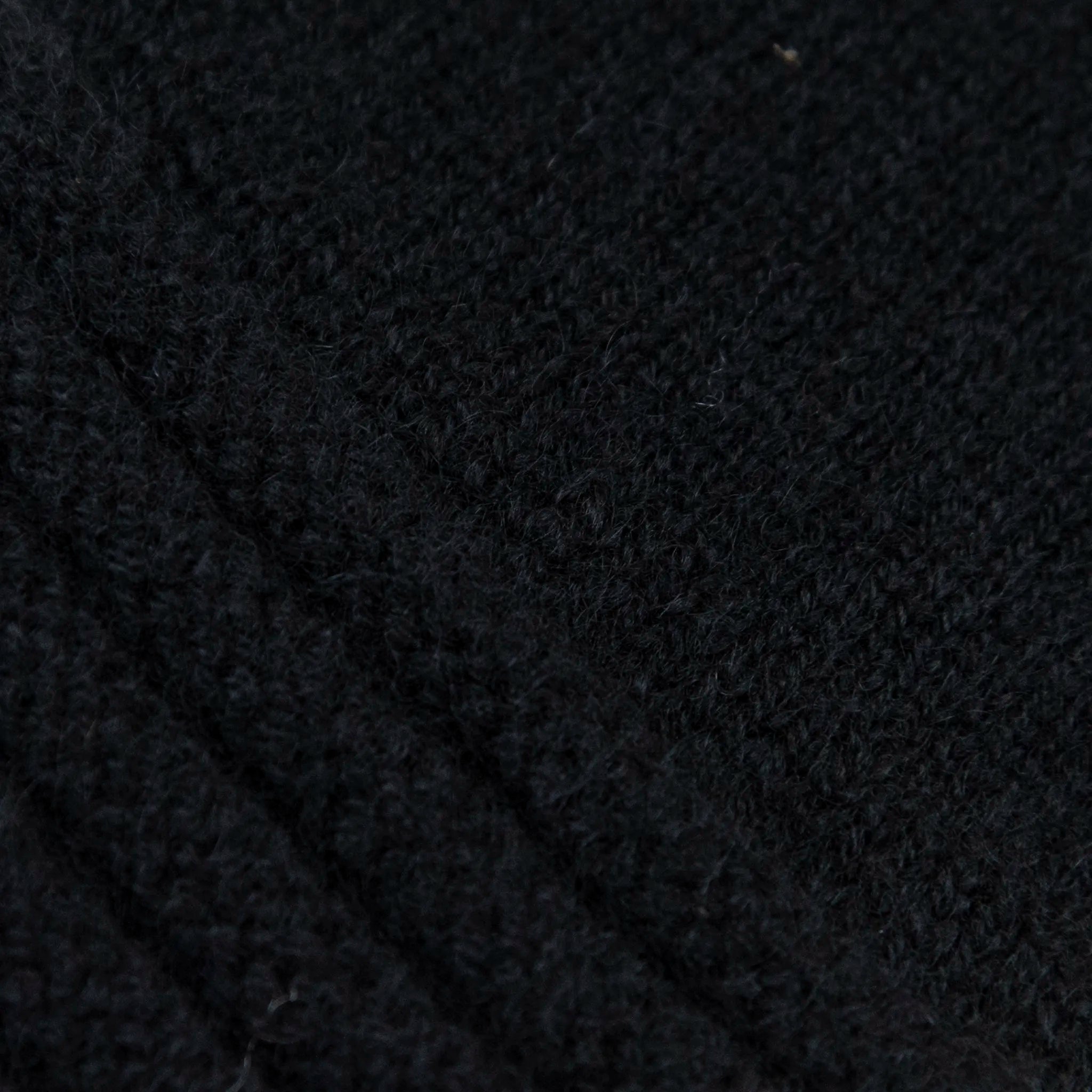 Dettagli e texture tessuto del guanto nero in 100% cashmere a coste inglesi, indossabile lungo o corto, pregiata manifattura Made in Italy.