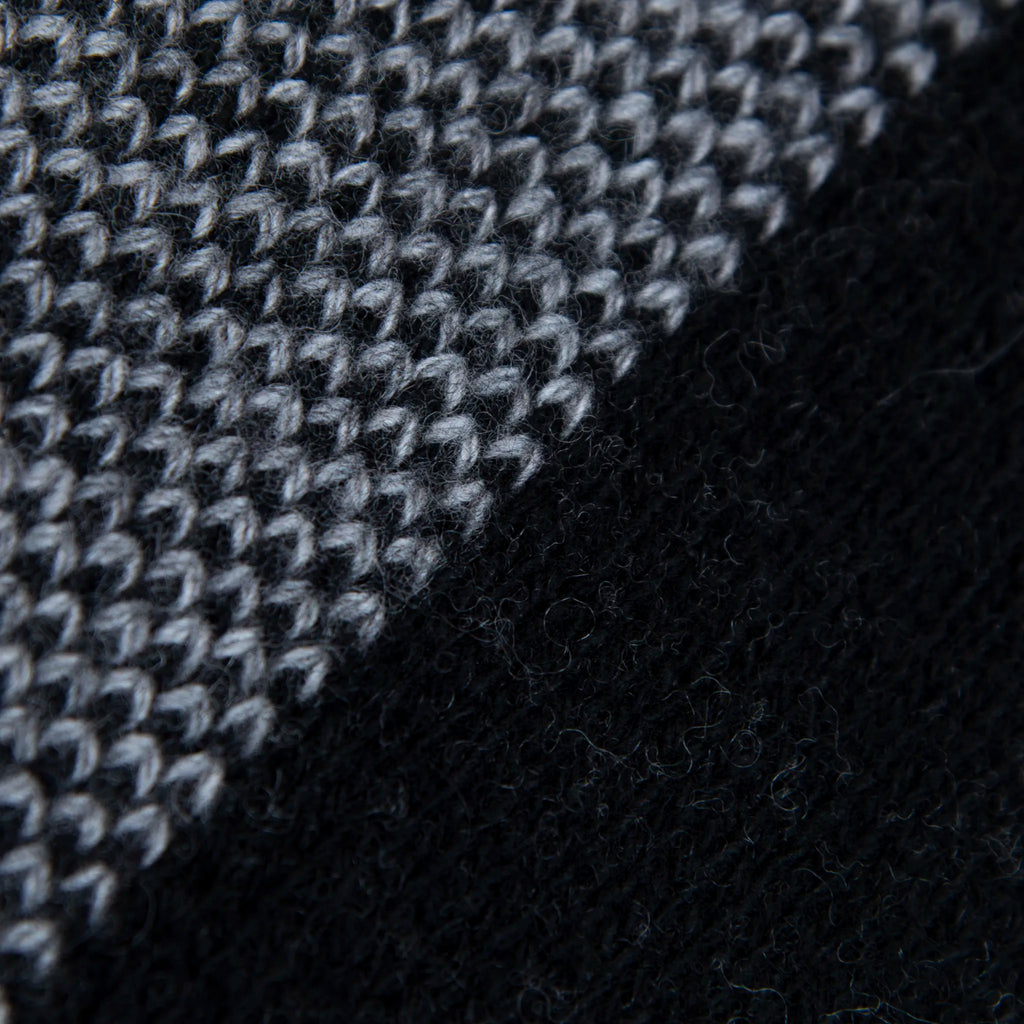 Dettaglio e texture tessuto della mantellina aperta nera e grigia in misto cashmere Made in Italy, versatile e confortevole, con due diverse vestibilità per adattarsi a ogni stile e occasione.