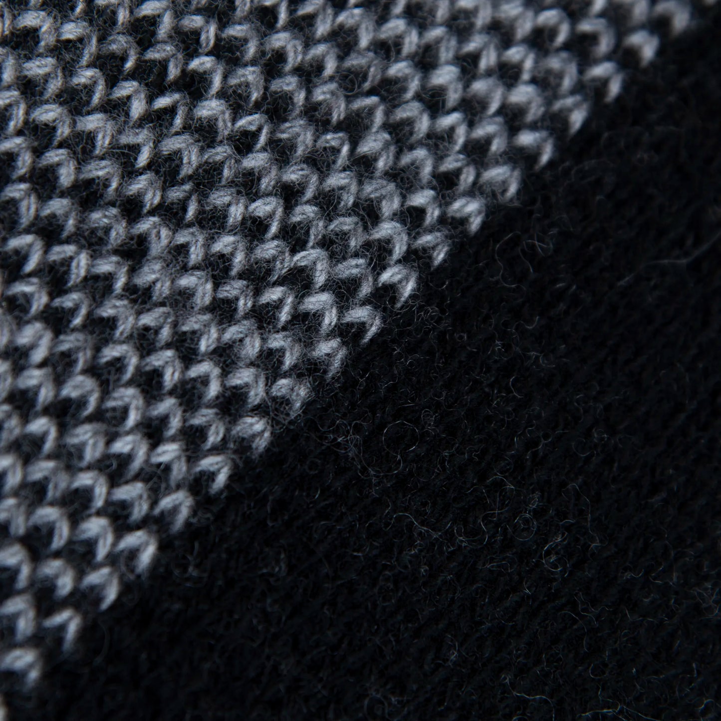 Dettaglio e texture tessuto della mantellina aperta nera e grigia in misto cashmere Made in Italy, versatile e confortevole, con due diverse vestibilità per adattarsi a ogni stile e occasione.