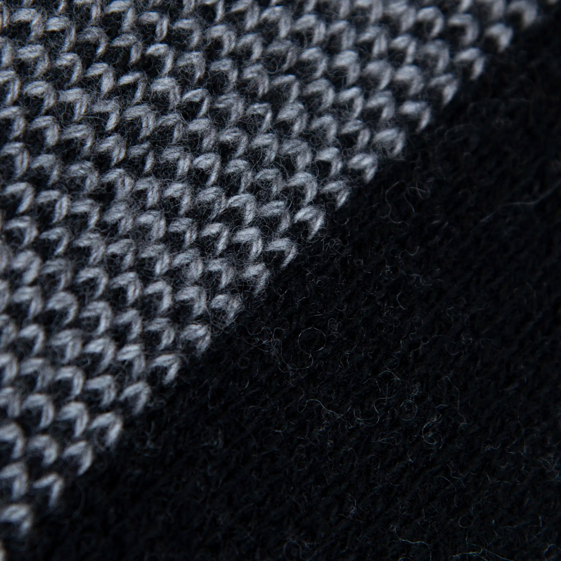 Dettaglio e texture tessuto della mantellina aperta nera e grigia in misto cashmere Made in Italy, versatile e confortevole, con due diverse vestibilità per adattarsi a ogni stile e occasione.