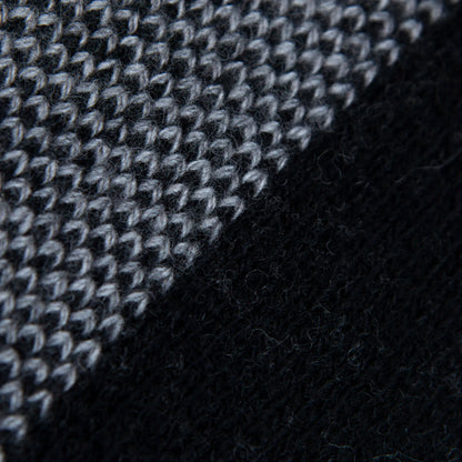 Dettaglio e texture tessuto della mantellina aperta nera e grigia in misto cashmere Made in Italy, versatile e confortevole, con due diverse vestibilità per adattarsi a ogni stile e occasione.