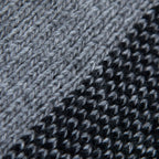 Dettaglio e texture tessuto della mantellina aperta nera e grigia in misto cashmere Made in Italy, versatile e confortevole, con due diverse vestibilità per adattarsi a ogni stile e occasione.