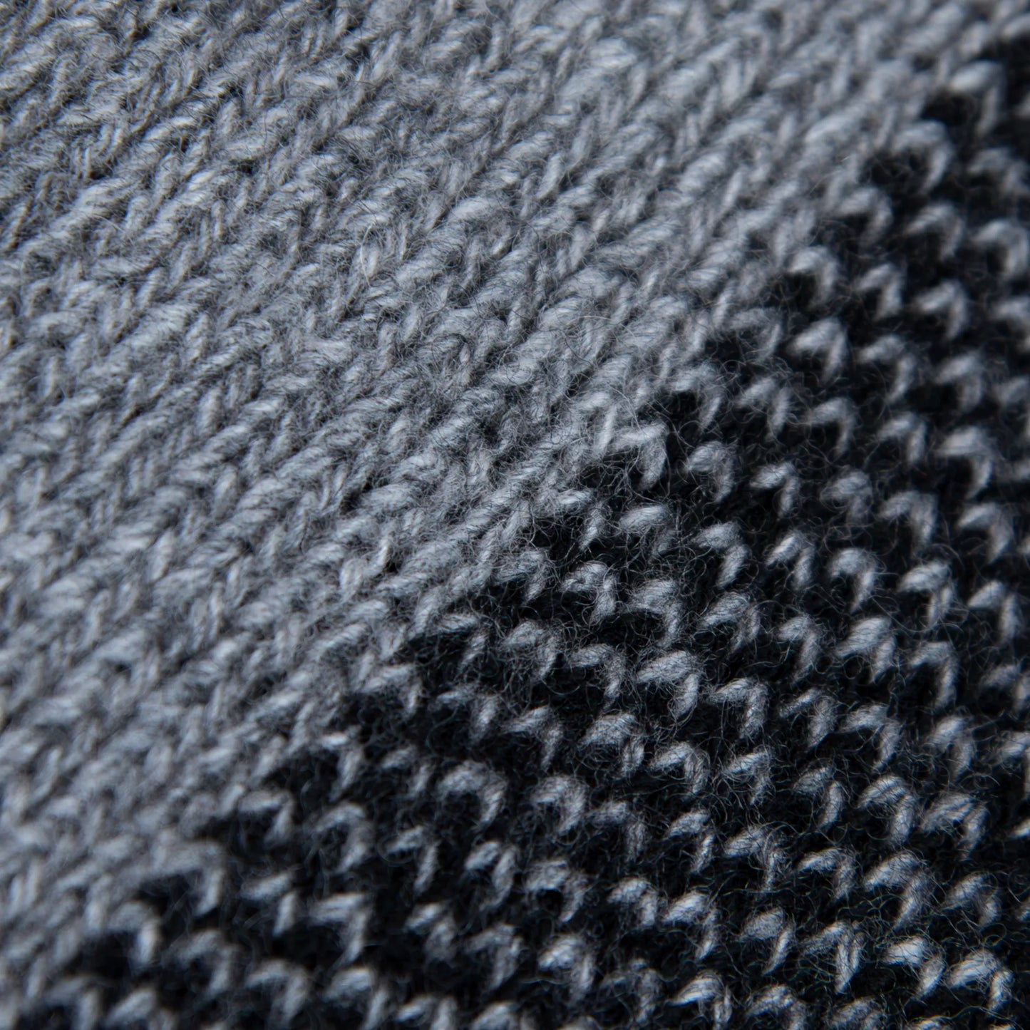 Dettaglio e texture tessuto della mantellina aperta nera e grigia in misto cashmere Made in Italy, versatile e confortevole, con due diverse vestibilità per adattarsi a ogni stile e occasione.