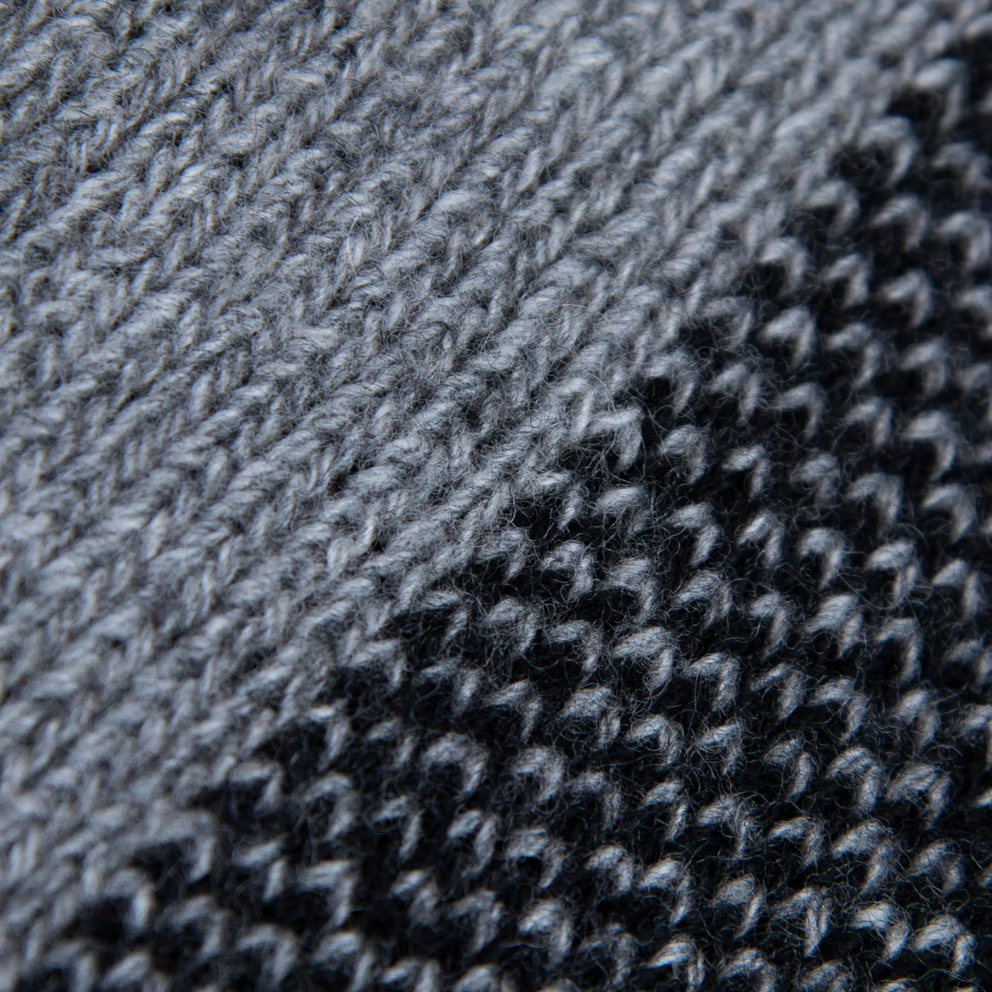 Dettaglio e texture tessuto della mantellina aperta nera e grigia in misto cashmere Made in Italy, versatile e confortevole, con due diverse vestibilità per adattarsi a ogni stile e occasione.