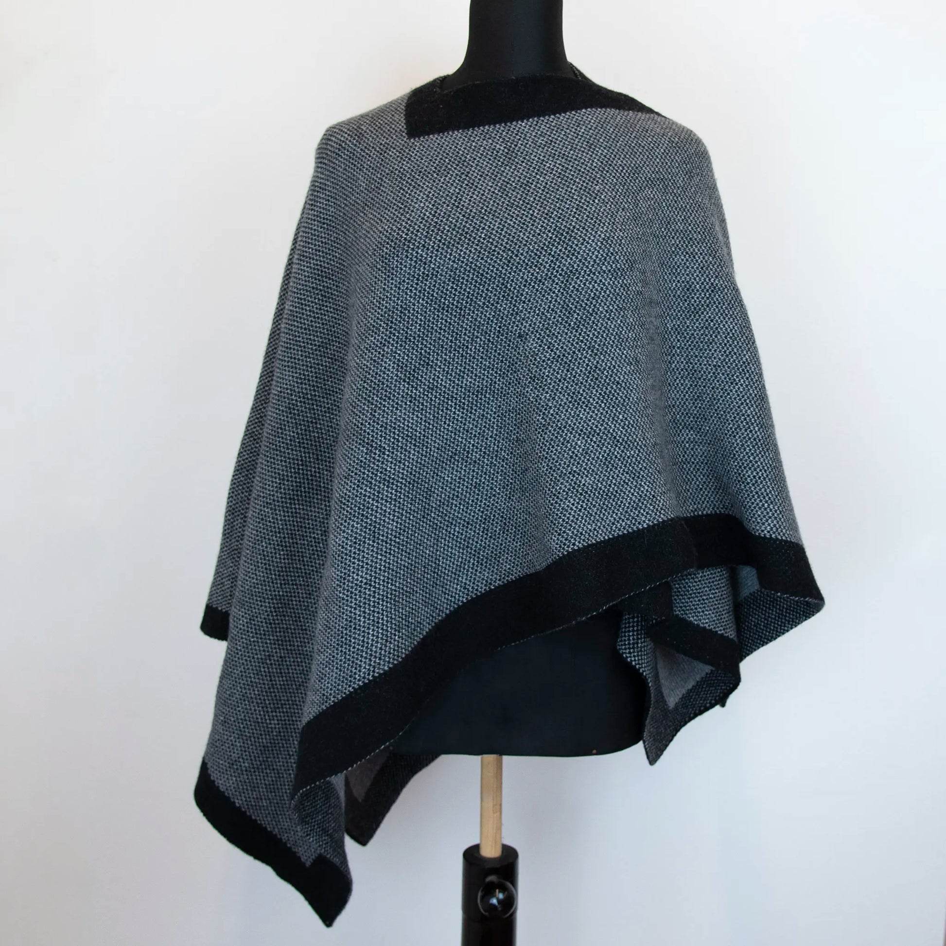 Mantellina aperta nera e grigia in misto cashmere Made in Italy, versatile e confortevole, con due diverse vestibilità per adattarsi a ogni stile e occasione.