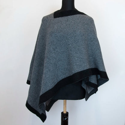 Mantellina aperta nera e grigia in misto cashmere Made in Italy, versatile e confortevole, con due diverse vestibilità per adattarsi a ogni stile e occasione.