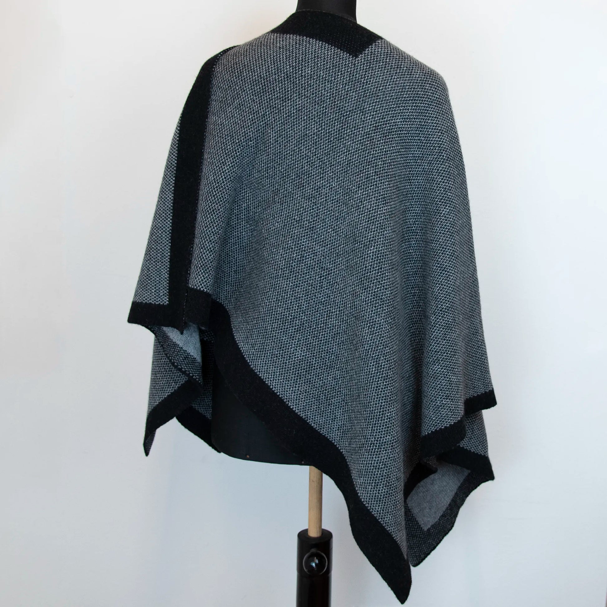 Mantellina aperta nera e grigia in misto cashmere Made in Italy, versatile e confortevole, con due diverse vestibilità per adattarsi a ogni stile e occasione.