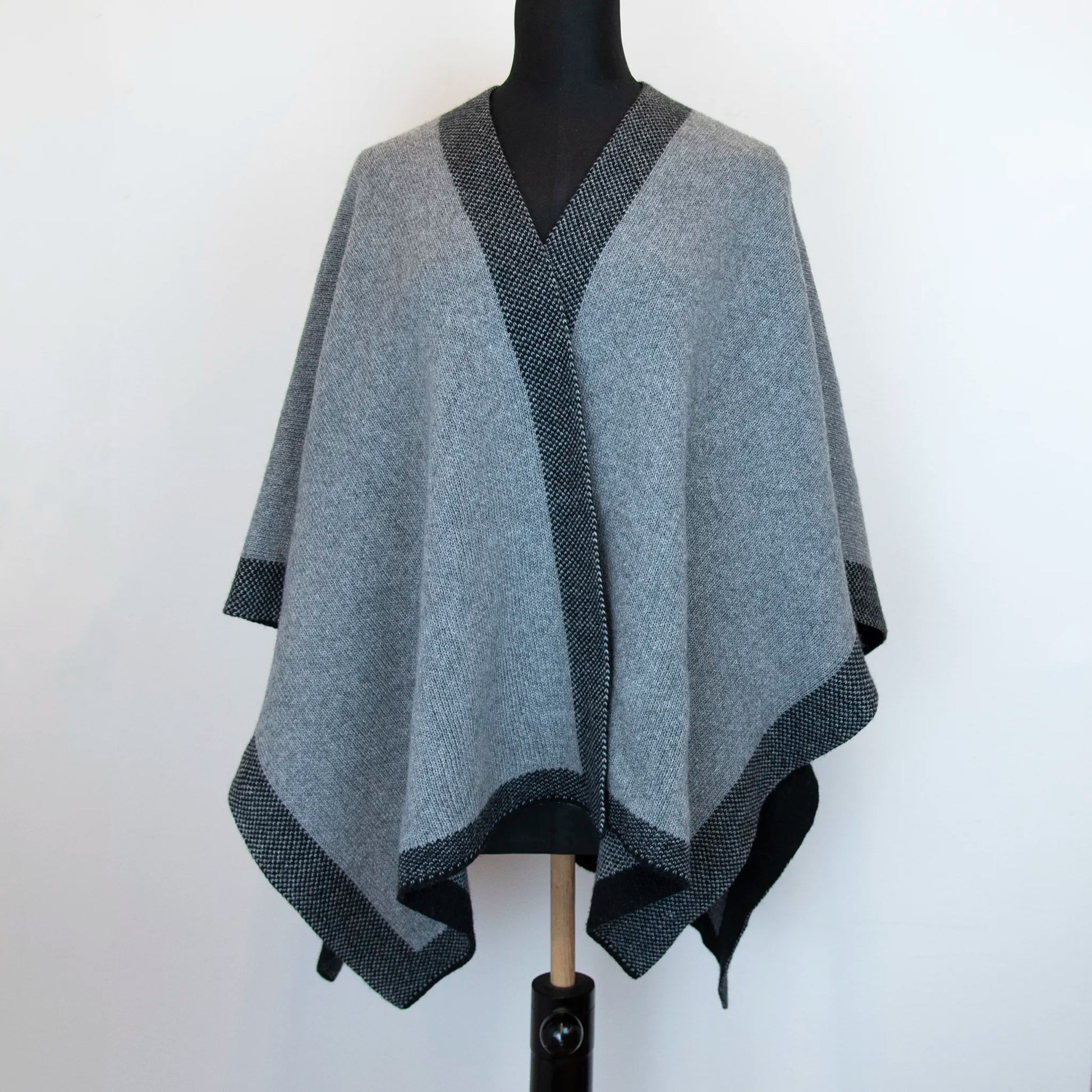 Mantellina aperta nera e grigia in misto cashmere Made in Italy, versatile e confortevole, con due diverse vestibilità per adattarsi a ogni stile e occasione.