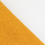 Dettaglio e texture tessuto della mantellina in 100% cashmere gialla, Made in Italy, praticità e comfort con tre diverse vestibilità per ogni esigenza.