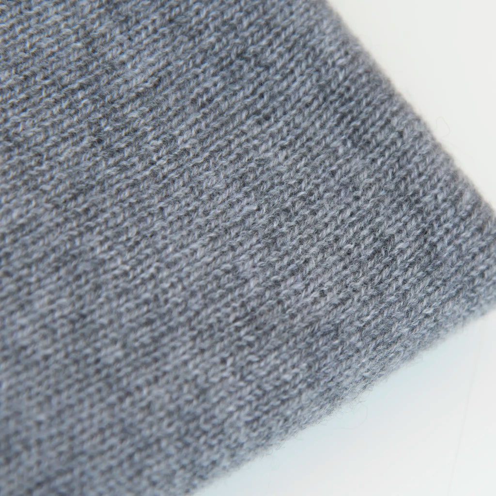 Dettaglio e texture tessuto della mantellina in 100% cashmere grigia, Made in Italy, praticità e comfort con tre diverse vestibilità per ogni esigenza.