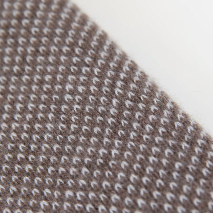 Dettaglio e texture tessuto della mantellina in 100% cashmere marrone e beige, Made in Italy, pratica e confortevole, con tre diverse vestibilità per adattarsi a ogni occasione.