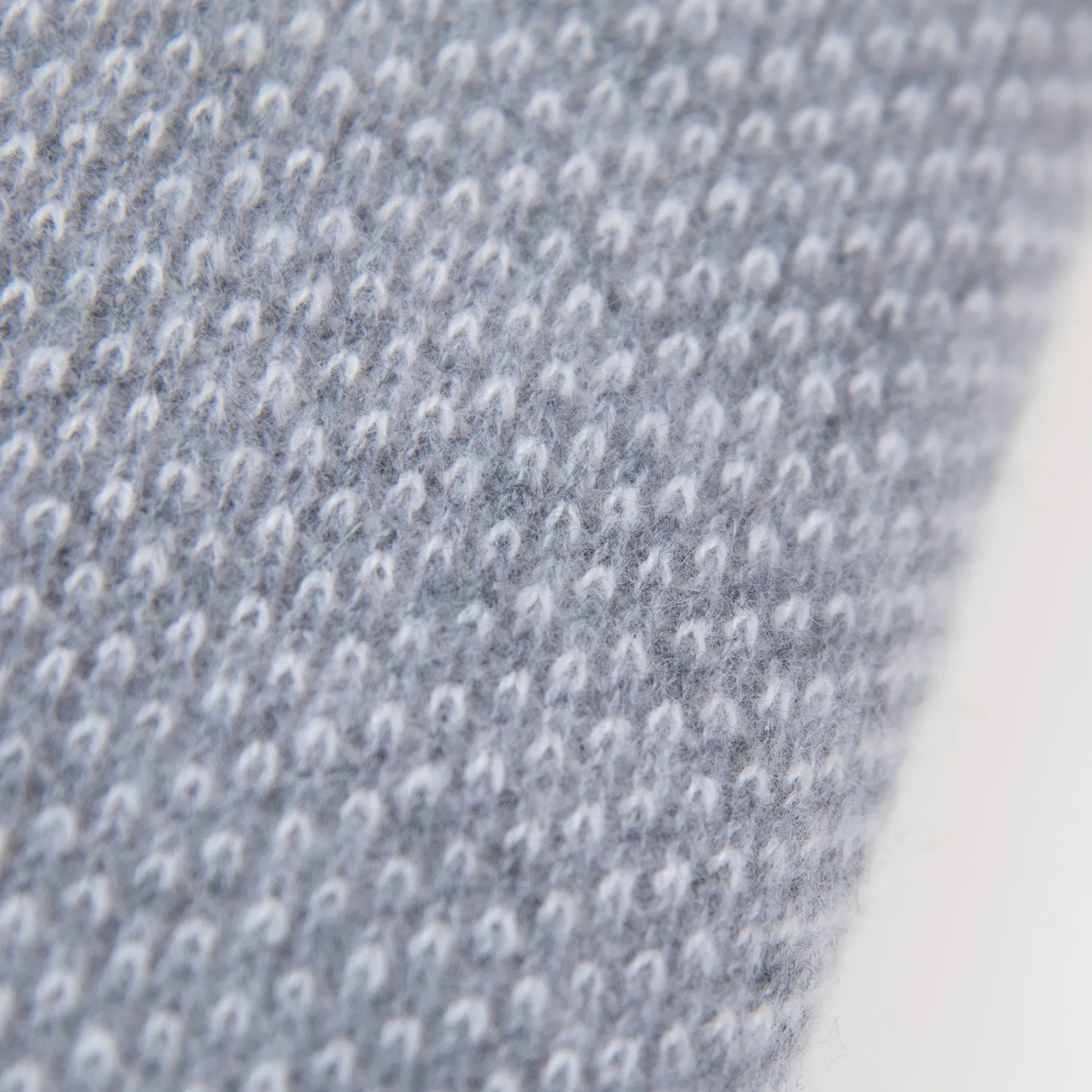 Dettaglio e texture tessuto della mantellina in 100% cashmere grigia, Made in Italy, pratica e confortevole, con tre diverse vestibilità per adattarsi a ogni occasione.