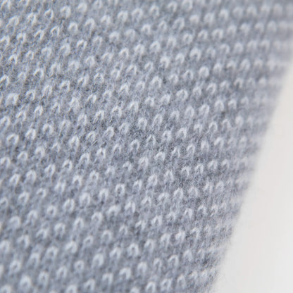 Dettaglio e texture tessuto della mantellina in 100% cashmere grigia, Made in Italy, pratica e confortevole, con tre diverse vestibilità per adattarsi a ogni occasione.