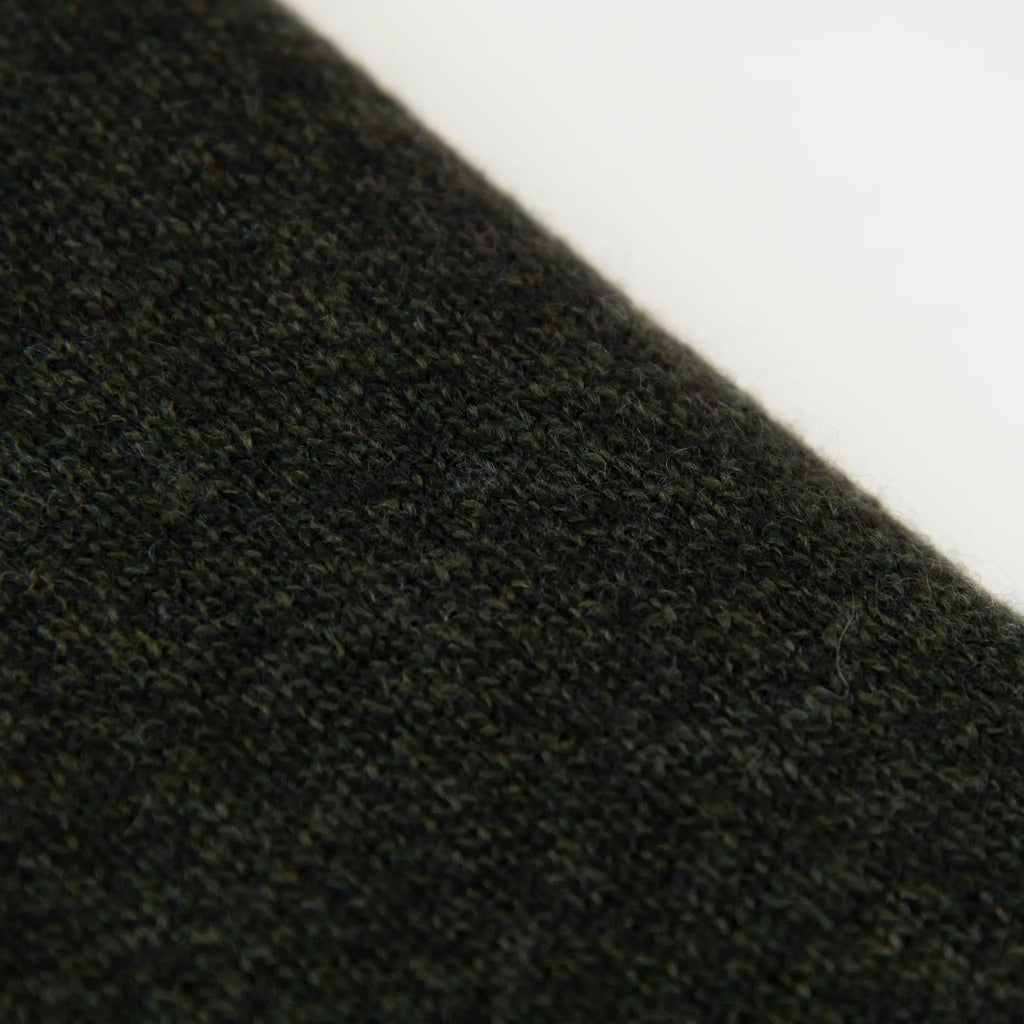 Dettaglio e texture tessuto della mantellina in 100% cashmere verde, Made in Italy, pratica e confortevole, con tre diverse vestibilità per adattarsi a ogni occasione.