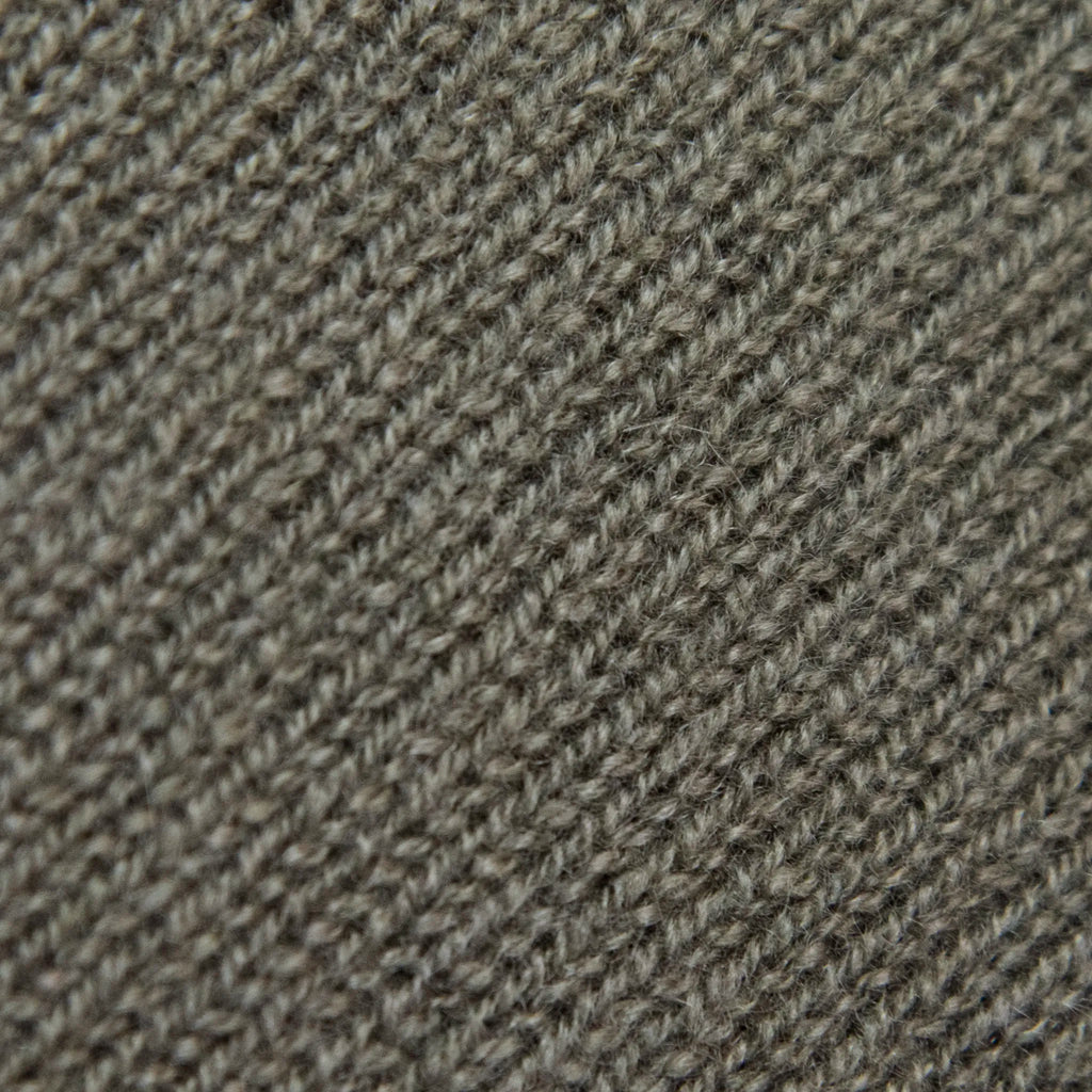 Dettagli e texture tessuto della Mantellina in 100% cashmere verde, Made in Italy, praticità e comfort con tre diverse vestibilità per ogni esigenza.