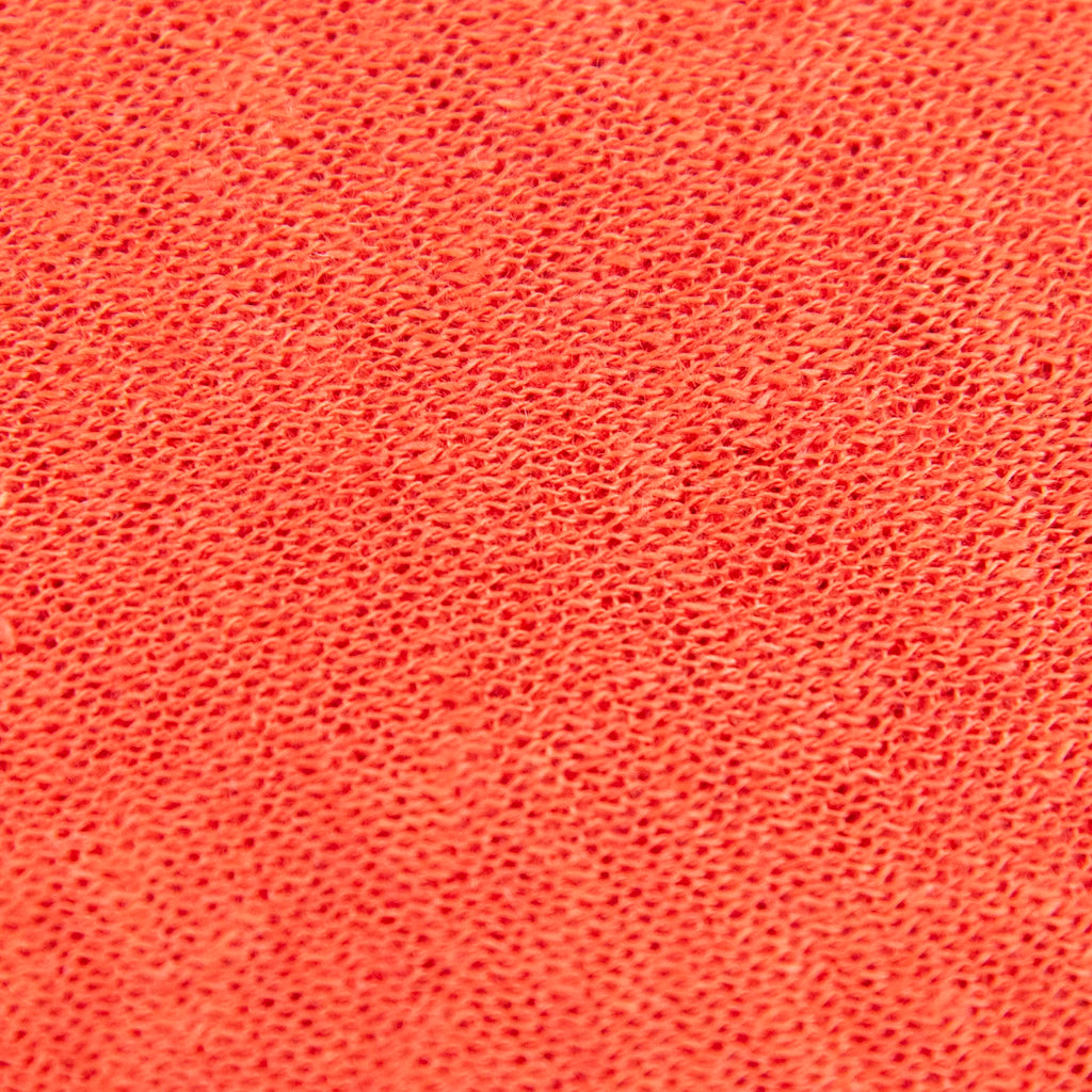 Dettagli e texture tessuto della mantellina in 100% Lino arancio, Made in Italy, praticità e comfort con tre diverse vestibilità per ogni esigenza.
