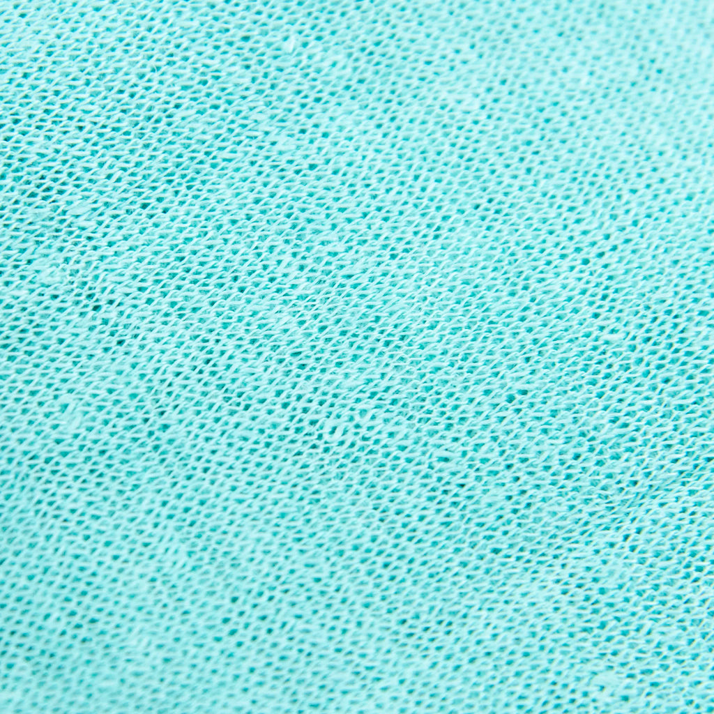 Dettagli e texture tessuto della mantellina in 100% Lino verde acqua, Made in Italy, praticità e comfort con tre diverse vestibilità per ogni esigenza.