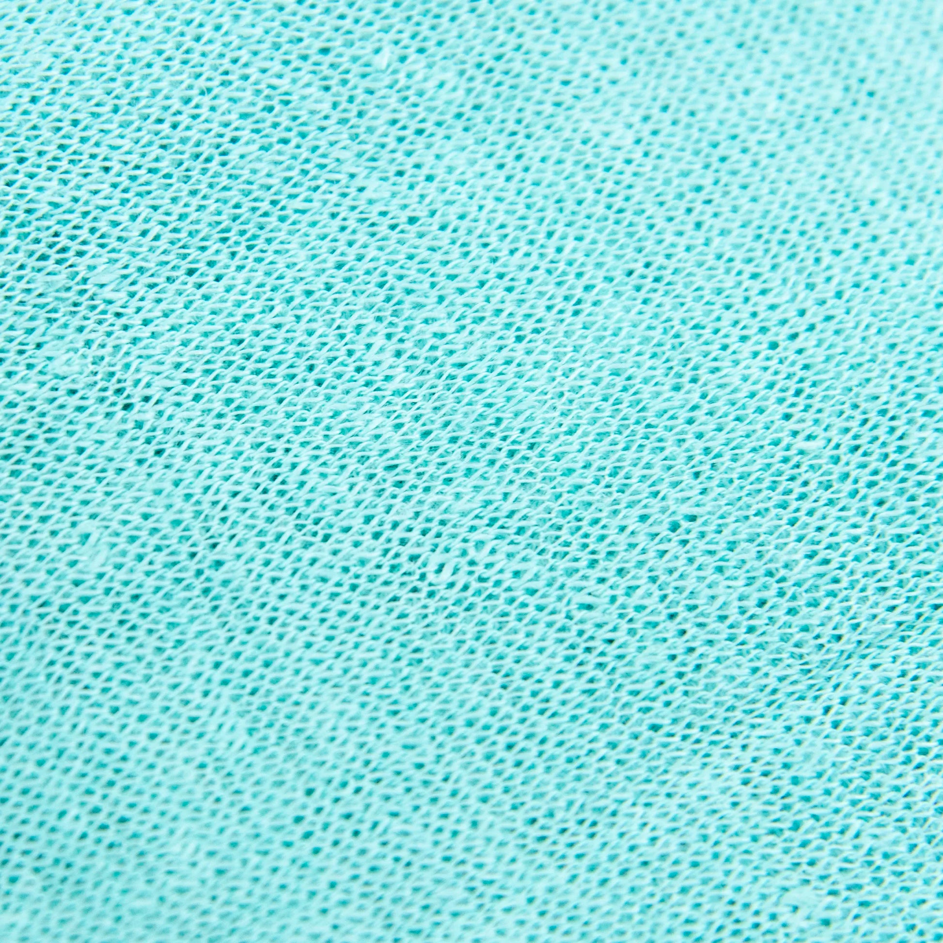 Dettagli e texture tessuto della mantellina in 100% Lino verde acqua, Made in Italy, praticità e comfort con tre diverse vestibilità per ogni esigenza.