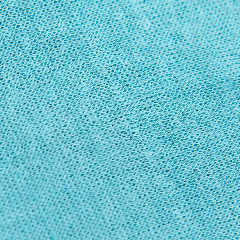 Dettagli e texture tessuto della mantellina in 100% Lino celeste, Made in Italy, praticità e comfort con tre diverse vestibilità per ogni esigenza.