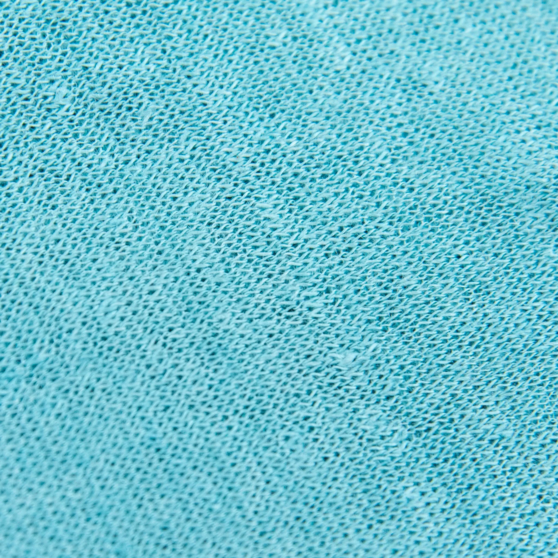 Dettagli e texture tessuto della mantellina in 100% Lino celeste, Made in Italy, praticità e comfort con tre diverse vestibilità per ogni esigenza.