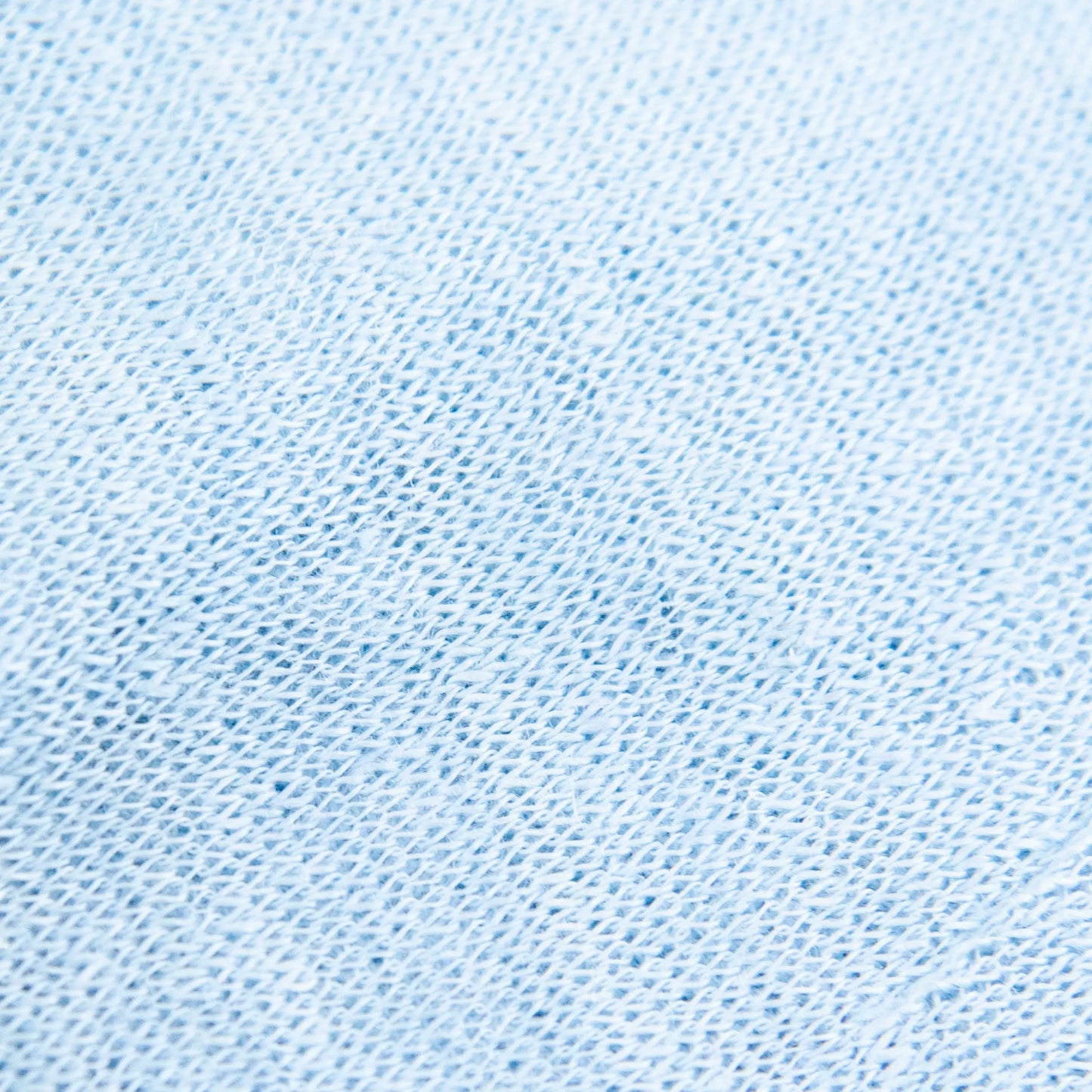 Dettagli e texture tessuto della mantellina in 100% Lino celeste, Made in Italy, praticità e comfort con tre diverse vestibilità per ogni esigenza.