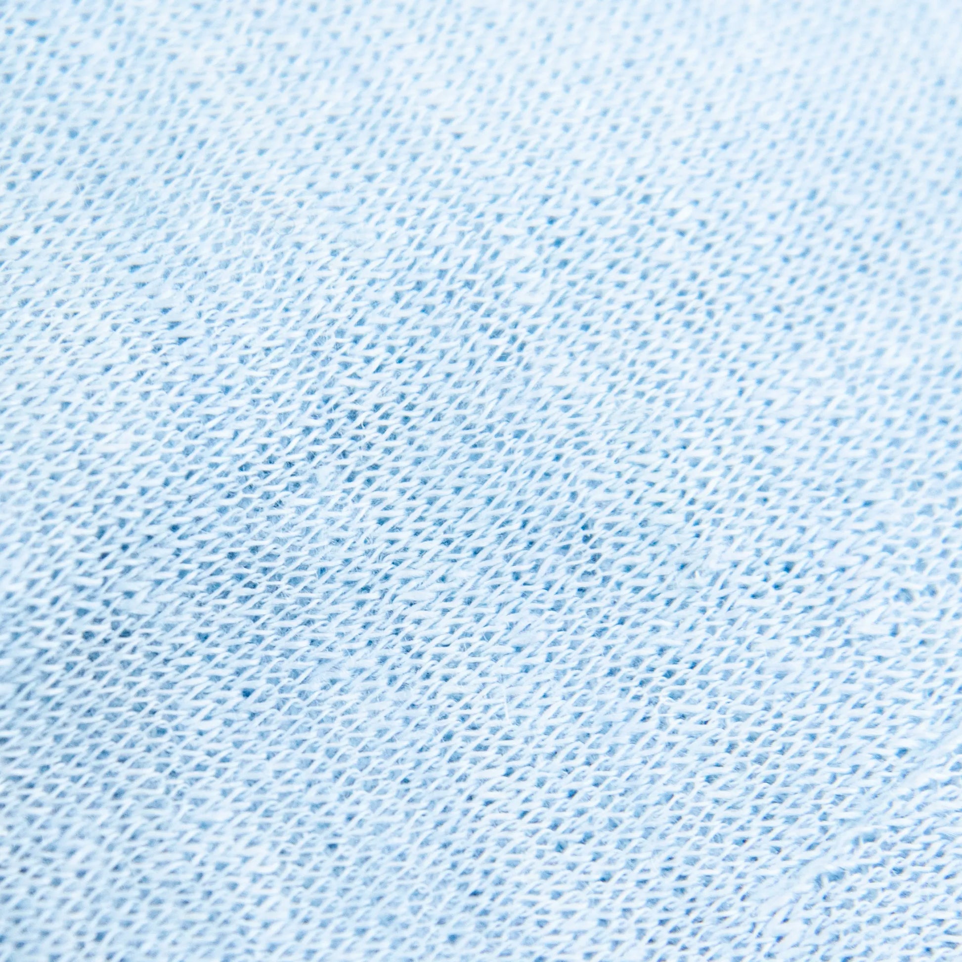 Dettagli e texture tessuto della mantellina in 100% Lino celeste, Made in Italy, praticità e comfort con tre diverse vestibilità per ogni esigenza.