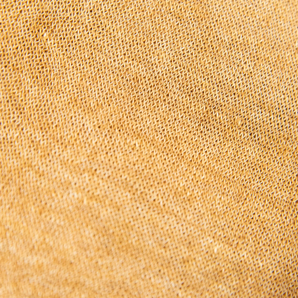 Dettagli e texture della mantellina in 100% Lino senape, Made in Italy, praticità e comfort con tre diverse vestibilità per ogni esigenza.