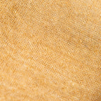 Dettagli e texture della mantellina in 100% Lino senape, Made in Italy, praticità e comfort con tre diverse vestibilità per ogni esigenza.