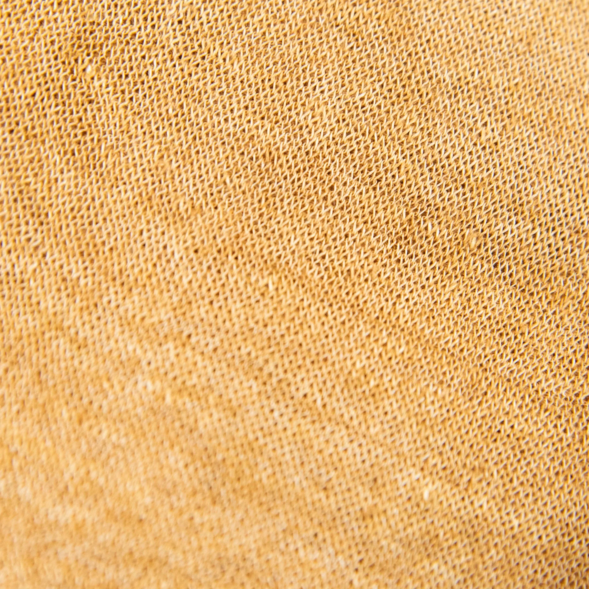 Dettagli e texture della mantellina in 100% Lino senape, Made in Italy, praticità e comfort con tre diverse vestibilità per ogni esigenza.
