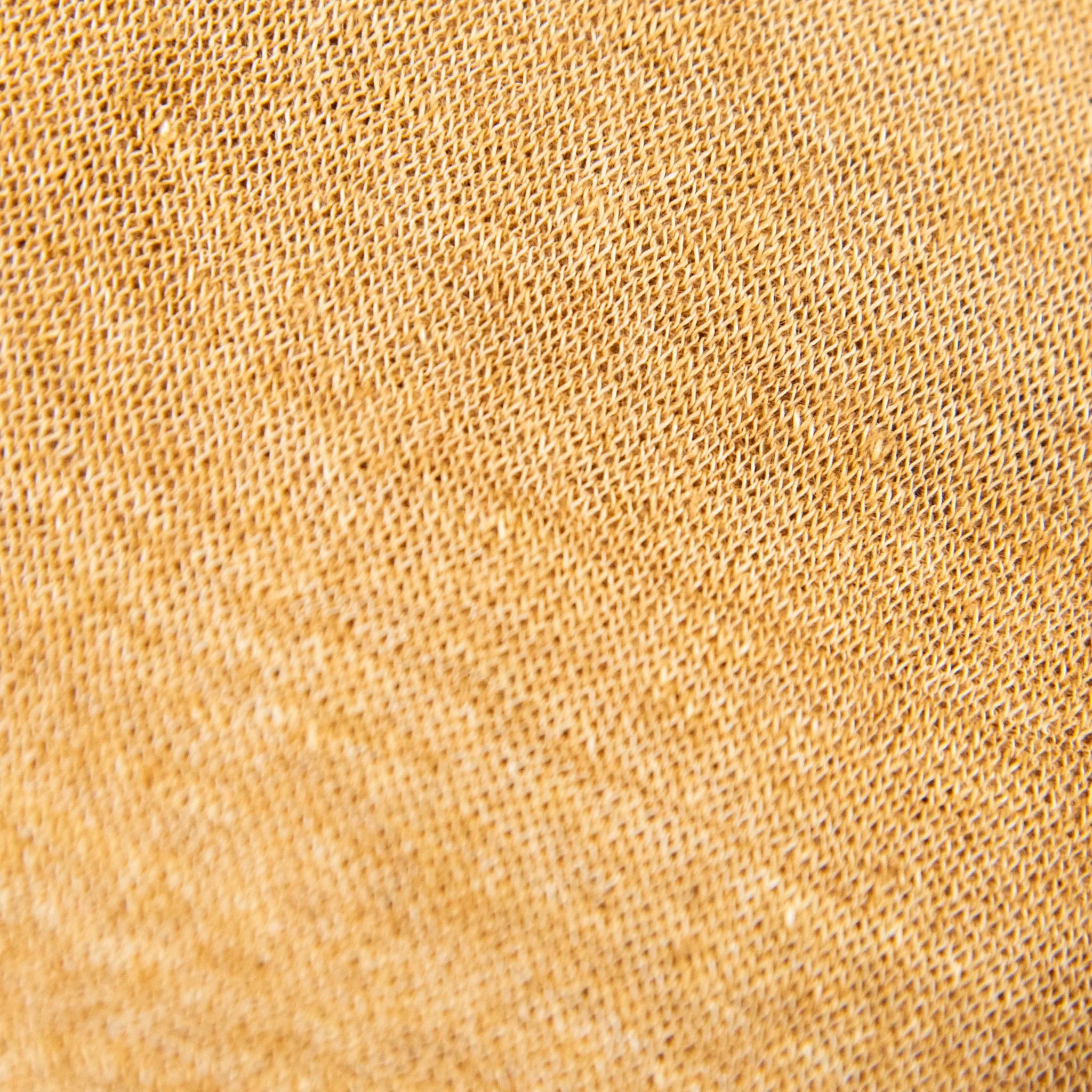 Dettagli e texture della mantellina in 100% Lino senape, Made in Italy, praticità e comfort con tre diverse vestibilità per ogni esigenza.