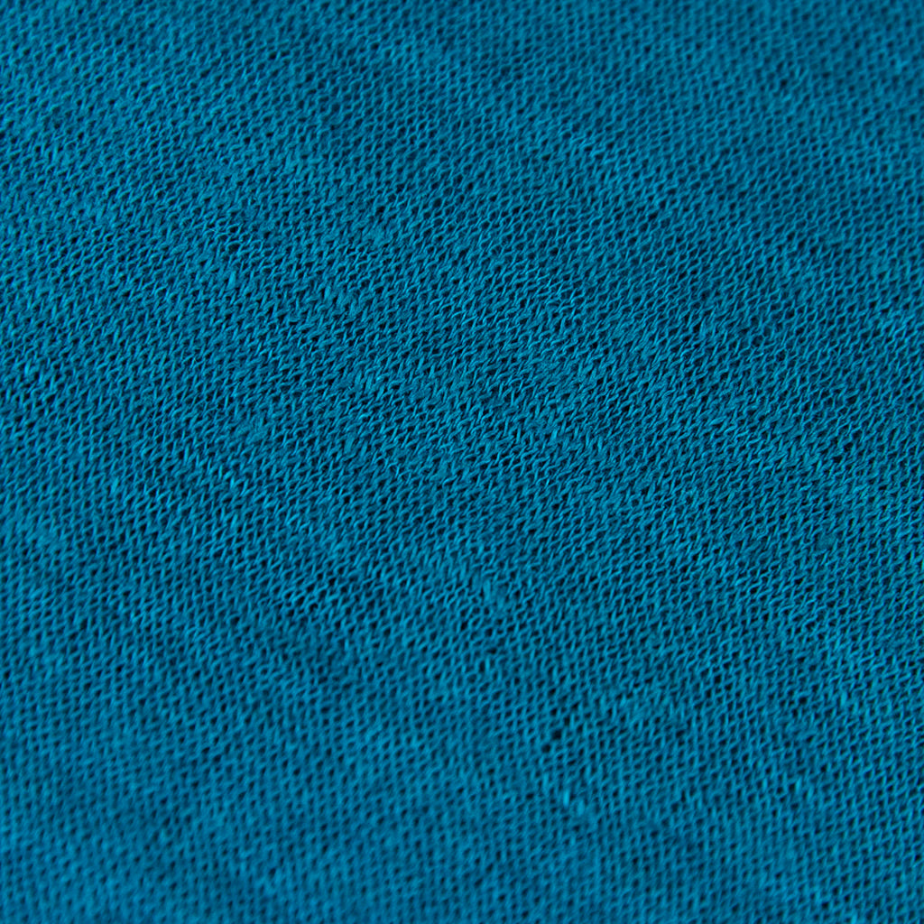 Dettagli e texture tessuto della mantellina in 100% Lino turchese, Made in Italy, praticità e comfort con tre diverse vestibilità per ogni esigenza.