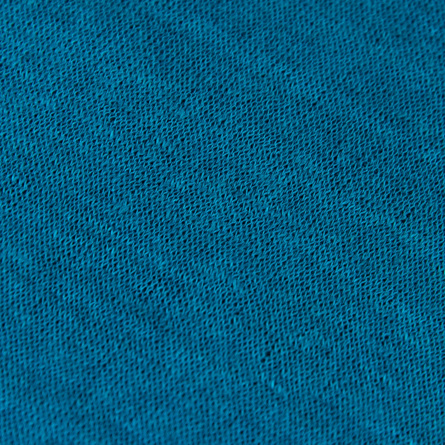 Dettagli e texture tessuto della mantellina in 100% Lino turchese, Made in Italy, praticità e comfort con tre diverse vestibilità per ogni esigenza.