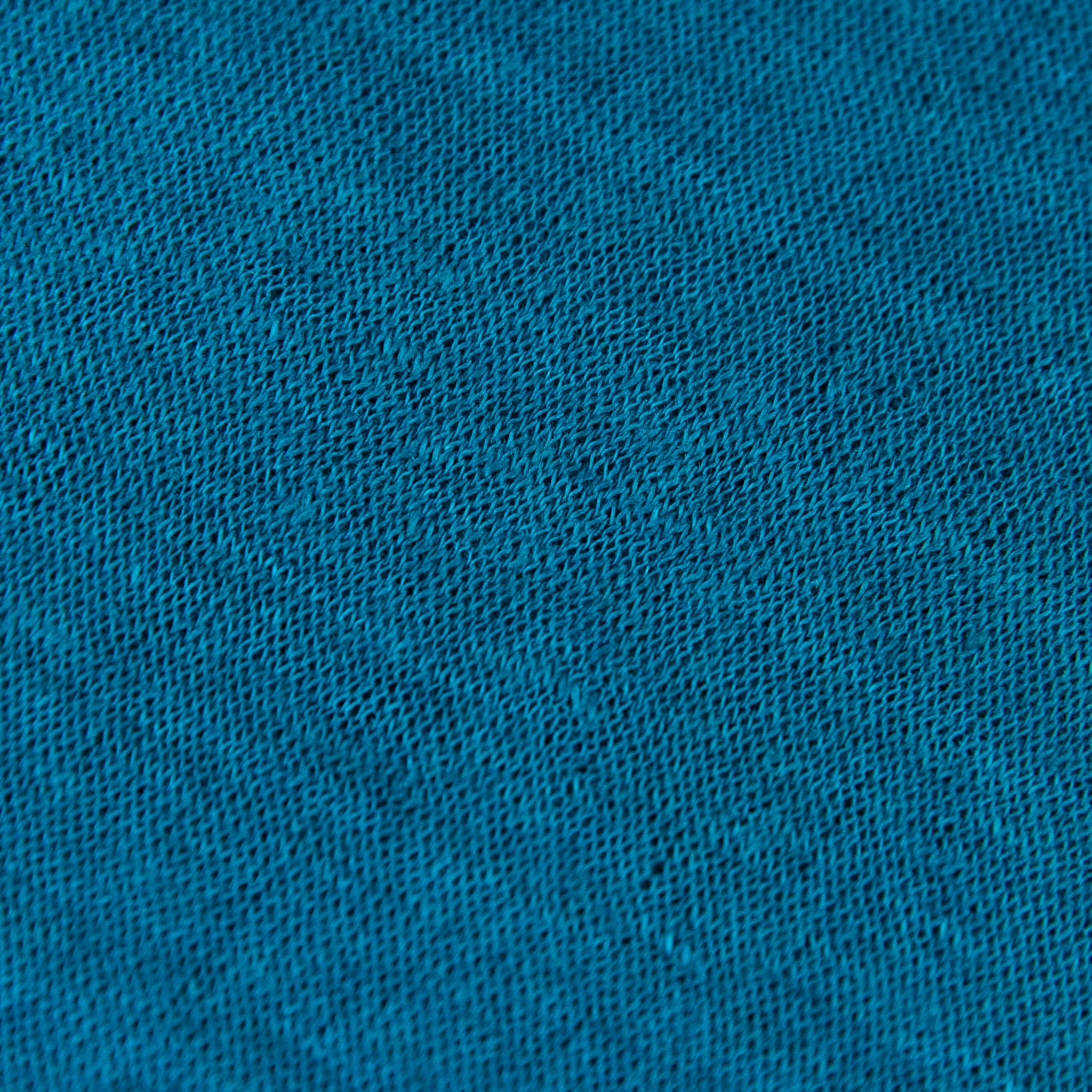 Dettagli e texture tessuto della mantellina in 100% Lino turchese, Made in Italy, praticità e comfort con tre diverse vestibilità per ogni esigenza.
