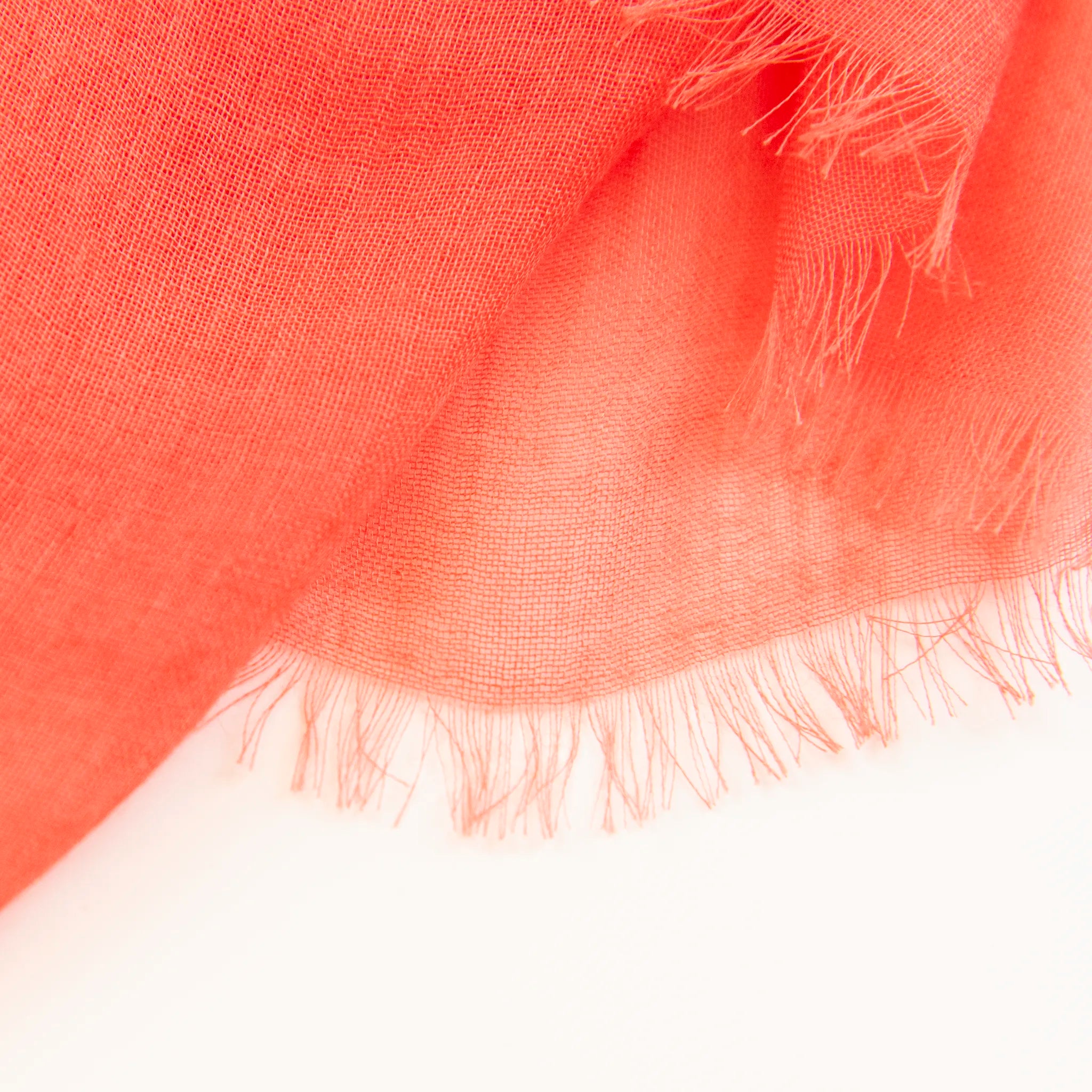 Dettagli e texture della Pashmina in cashmere e modal arancio a tessitura twill, pregiata manifattura Made in Italy, sottile ed elegante adatta a ogni stagione.