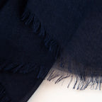 Dettagli e texture della Pashmina in 100% cashmere blu a tessitura twill, pregiata manifattura Made in Italy, sottile ed elegante adatta a ogni stagione.
