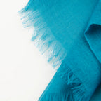 Dettagli e texture della Pashmina in cashmere e modal blu a tessitura twill, pregiata manifattura Made in Italy, sottile ed elegante adatta a ogni stagione.