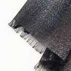Dettagli e texture della Pashmina in cashmere e modal nera brillantinata a tessitura twill, pregiata manifattura Made in Italy, sottile ed elegante adatta a ogni stagione.