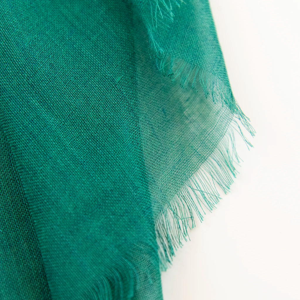 Dettagli e texture della Pashmina in cashmere e modal verde a tessitura twill, pregiata manifattura Made in Italy, sottile ed elegante adatta a ogni stagione.