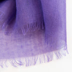 Dettagli e texture della Pashmina in cashmere e modal viola a tessitura twill, pregiata manifattura Made in Italy, sottile ed elegante adatta a ogni stagione.