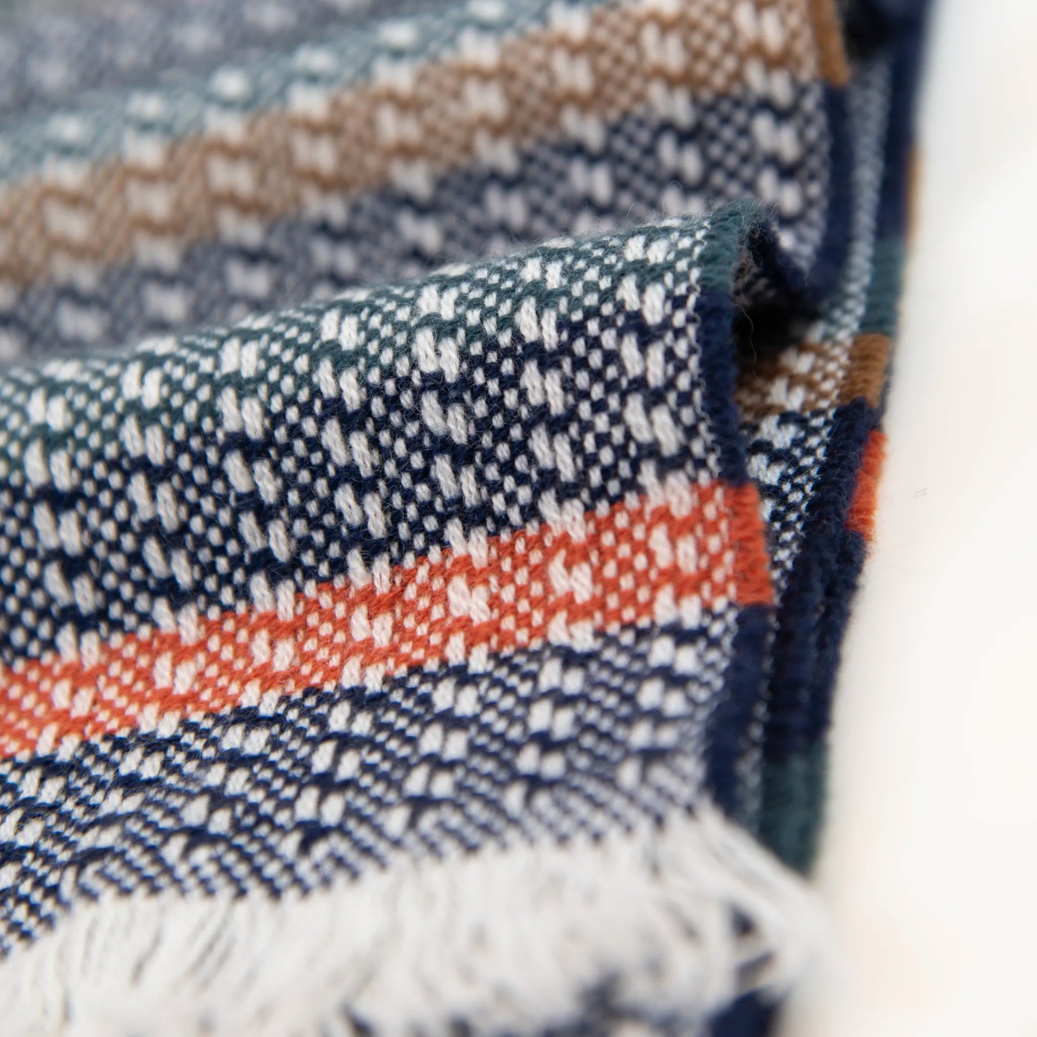 Dettaglio e texture tessuto della sciarpa in 100% cashmere, realizzata in Italia con ricamo 3D su filato naturale, senza pigmenti. Lavorazione artigianale su telai antichi garantisce durata e qualità. Design esclusivo, con colori creati da designer per un capo elegante e versatile.